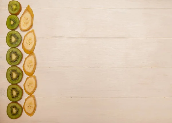 Ακτινίδιο και μπανάνα σε λευκό ξύλινο φόντο με χώρο για κείμενο close-up για σχεδιασμό και κείμενο — Φωτογραφία Αρχείου