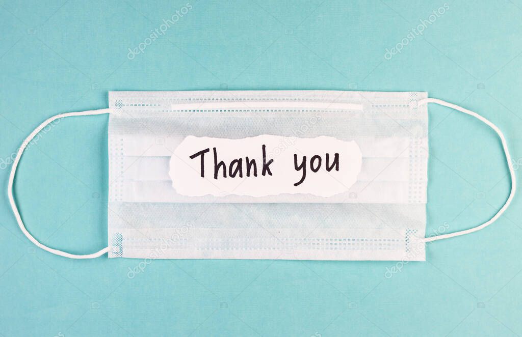 medical mask and the inscription Thank you on a blue background. concept of gratitude to medical workers during the coronavirus pandemic