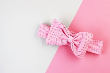 Pembe fiyonk, pembe ve beyaz arka planda baş süslemesi. Lastik bantlı kadın aksesuarı.