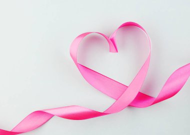 Pembe kalp kurdelesi mavi arka planda izole edilmiş. Kalp şeklinde ipek kumaş. Sevgililer Günü için arkaplan