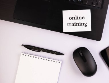 Kalemle birlikte not defteri ve çevrimiçi metin eğitimi. Masa üstü görünümlü siyah bir bilgisayar.