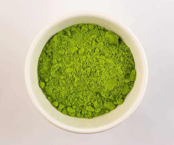 dry green tea powder matcha tea, isolate on a white background. Chinese healing soothing tea for health. Eastern grass