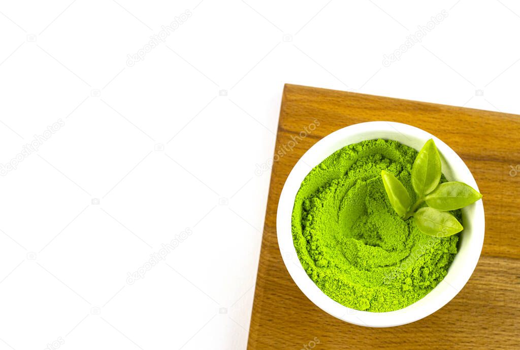dry green tea powder matcha tea with whole leaves, isolate on a white background. Chinese healing calming tea for health in a white bowl. Eastern grass