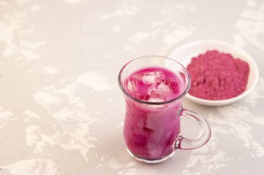 Gri arka planda süt ve buz küpleriyle moda pembe kibrit çay lattesi. Kilo ve sağlık için oryantal çay
