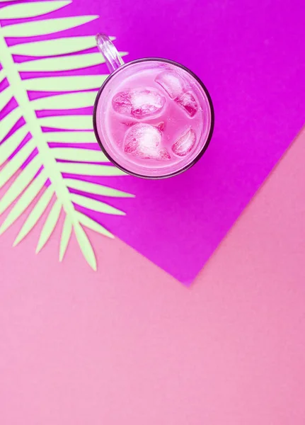 Trendy pink matcha tea latte with milk and ice cubes on an exotic background. Oriental tea for weight loss and health