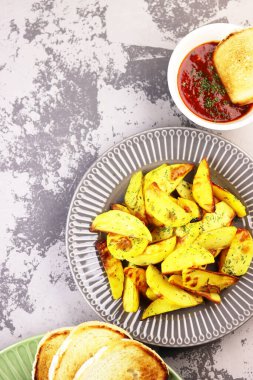 Sebzeli ve ketçaplı patatesler masaya yakın. Domates soslu kızarmış patates.