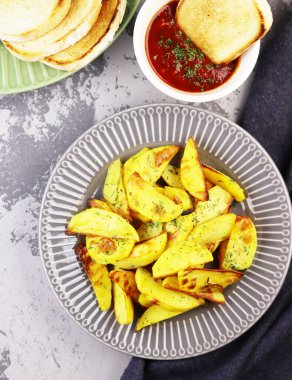 Sebzeli ve ketçaplı patatesler masaya yakın. Domates soslu kızarmış patates.