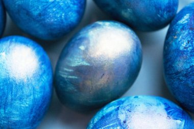 Beyaz arka planda mavi Paskalya yumurtaları, yakın plan. Tatil yumurtaları bir yığın halinde toplanır. Paskalya bayramı için arka plan