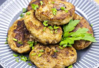 Tabağında yeşil sebzeler olan taze kızarmış pirzolalar, yakın plan. Vahşi erkek yiyeceği