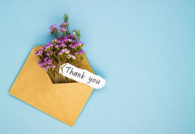 Zarfın içinde bir buket yaban çiçeği ve yazıtlar için teşekkür ederim. Tıp işçilerine yaptıkları iş için minnettarlık kavramı.