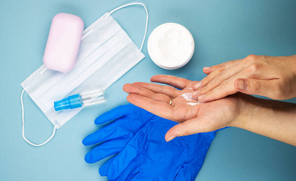 Женские медицинские руки заботятся о коже рук после снятия перчаток, вид сверху. увлажняющий и питательный крем для рук, поврежденных антисептиками и дезинфицирующими средствами
