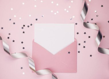 Açık pembe bir zarf, beyaz bir sayfa, mesaj için boşluk. Pembe arka planda, parlak konfeti yıldızları. Kadın bayramı ve Sevgililer Günü kavramı