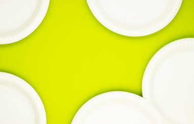 Çevre dostu, yeşil arka planda biyolojik olarak çözünebilen kağıt tabaklar. Doğanın saflığını korumak. Plastiğin reddi.