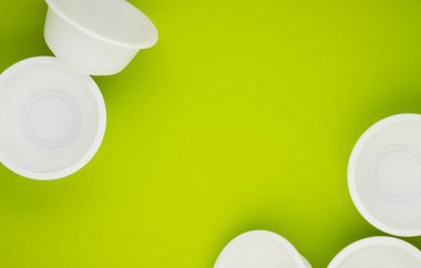 Yeşil arka planda biyolojik olarak bozunabilir yiyecek kapları, metin için alan. Doğayla ilgilenmek. Çevre kirliliğini azaltıyor. Plastik tabakların reddi