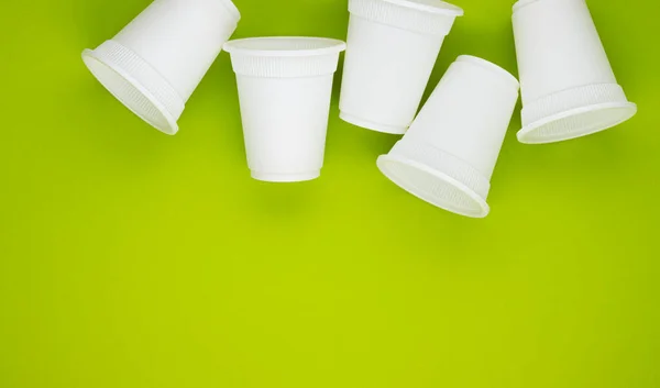 biodegradable beverage containers on a green background, space for text. environmental protection. caring for nature. the rejection of the plastic