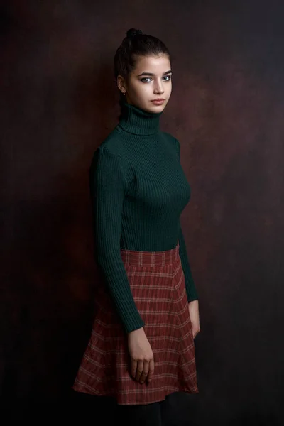 Una Ragazza Maglione Verde Gonna Uno Sfondo Scuro — Foto Stock