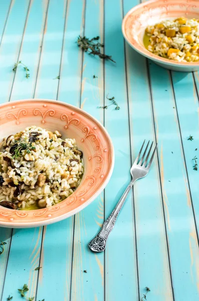 Delicious risotto with porcini mushrooms and pumpkin over wooden background — Stock Photo, Image