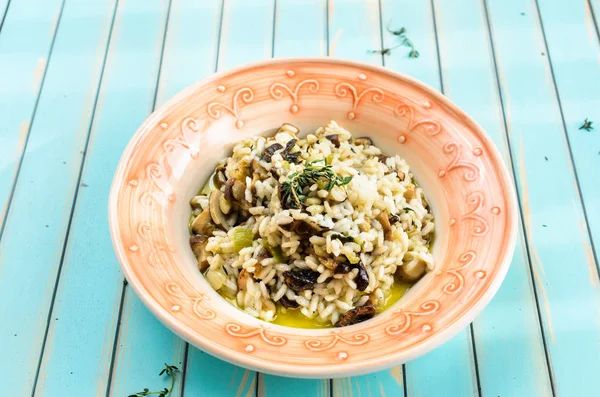 Deilig risotto med porcinisopp over turkis-bakgrunn av tre – stockfoto