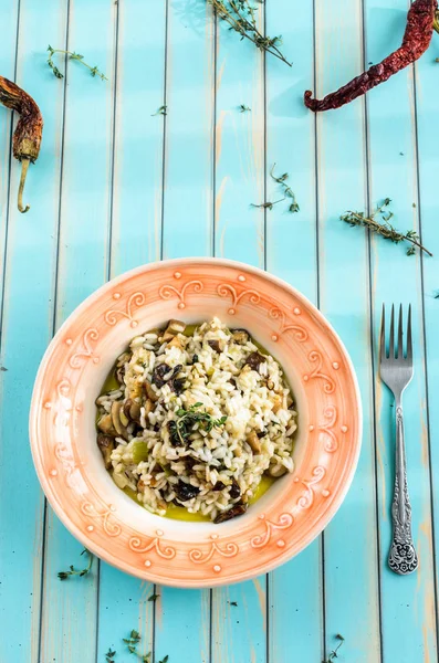 Delicious risotto with porcini mushrooms over wooden turquoise background — Stock Photo, Image