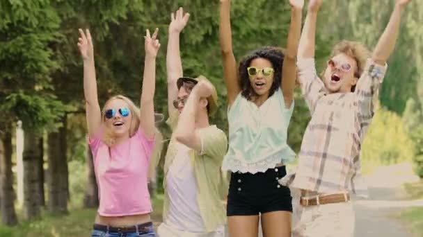 vier junge glückliche Menschen springen, die Hände in die Luft strecken, tanzen auf einem Musikfestival