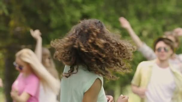 Szczęśliwy wesoły biracial dziewczyna potrząsając włosów, taniec na zewnątrz party z przyjaciółmi — Wideo stockowe