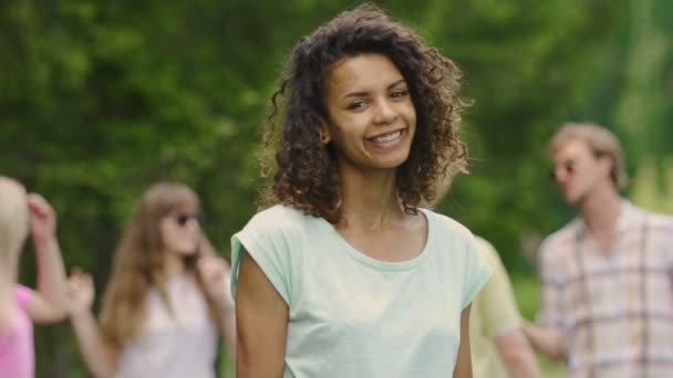 Jovencita con dientes blancos, piel perfecta sonriendo, bailando con amigos en la fiesta — Vídeo de stock