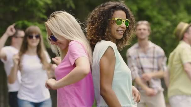 Dos mujeres atractivas realizando baile sexy espalda con espalda, jóvenes de fiesta — Vídeos de Stock