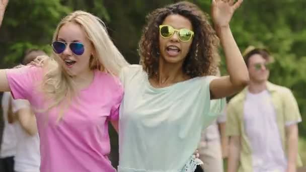 Two teenage girls dancing, having crazy fun with friends outdoors, summertime — Stock Video