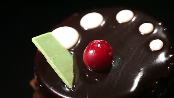 Demonstração de bolo doce com cobertura de chocolate e cereja, close-up — Vídeo de Stock