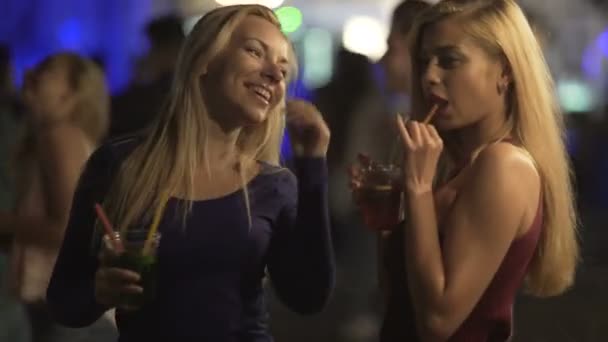 Senhoritas sedutoras bebendo coquetéis, movendo corpos sexy para a música na discoteca — Vídeo de Stock