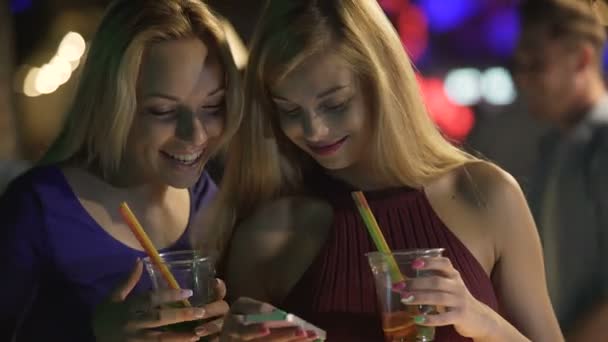 Rubias sexy compartiendo divertidas fotos en línea utilizando el teléfono inteligente, disfrutando de la fiesta del club — Vídeo de stock