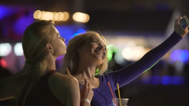 Upphetsad blondiner poserar för selfie på disco, gör ansikten till smartphone kamera — Stockvideo