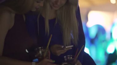 Güzel kız öğrenciler akıllı telefonda fotoğraflara gülüyor, birlikte eğleniyor