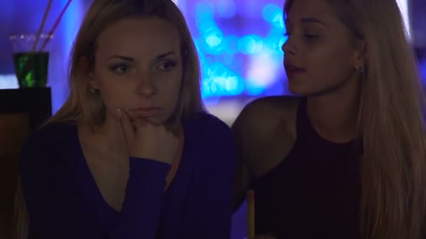 Depressed lady sitting upset at party, supportive female friend hugging her — Stock Video