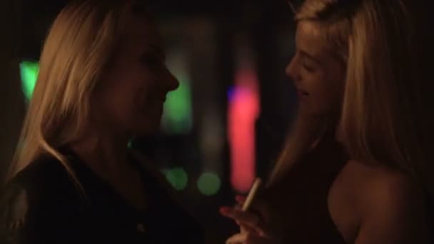 Возбужденные молодые женщины тратят жизнь в ночных клубах, танцуют и курят сигареты — стоковое видео