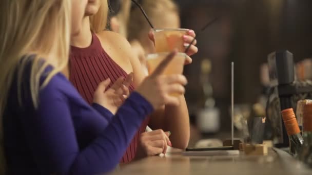 Hermosas señoritas de fiesta, disfrutando de cócteles alcohólicos cerca del mostrador del bar — Vídeo de stock