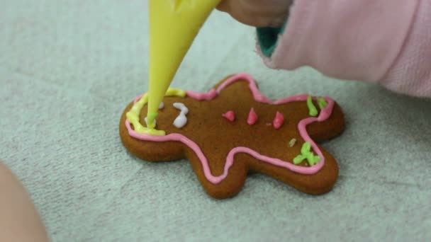 Руки девушки украшают имбирное печенье в форме человека, креативность, ручная работа — стоковое видео