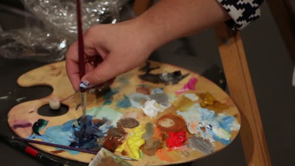 Mujer que moja el pincel en la paleta con pinturas al óleo, mano de obra de arte, hobby — Vídeo de stock