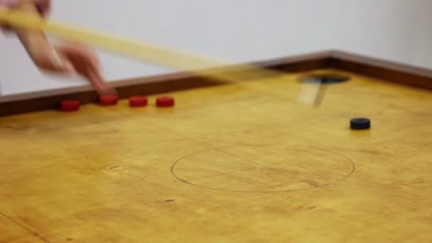 Amis jouant au jeu de table de carrom, fille marquant des points gagnants, temps libre — Video