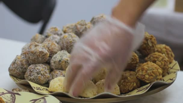 Vendedora poniendo caramelos hechos a mano en el paquete, confitería, festival de comida — Vídeos de Stock