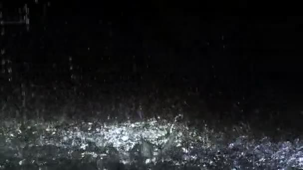 Regendruppels vallen in de fontein in de nacht, verse waterdrop tegen spatten op de grond — Stockvideo