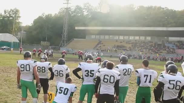 Ataque violento no campo durante o jogo de futebol americano, espectadores assistindo jogo — Vídeo de Stock