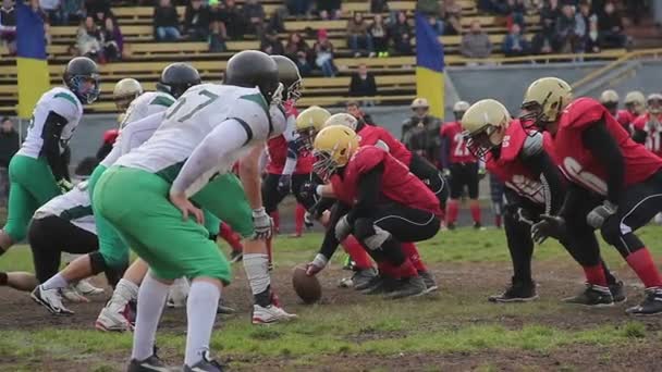 Gespannen moment op scrimmage lijn voor bal snap, voetbalteams klaar om te vechten — Stockvideo