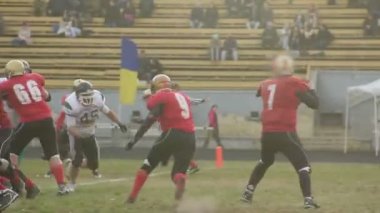 Kiev, Ukrayna - Yaklaşık Ekim 2015: Amerikan futbolu oynayan takımlar. Gridiron futbolcu savunma takımının gol çizgisine doğru ileri pas yapıyor