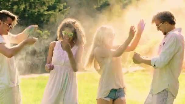 Amigos alegres jogando tinta em pó uns aos outros, festival Holi, prazer — Vídeo de Stock