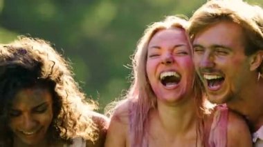 Genç kadın ve erkek ıslak giysileri ve renkli toz Holi partide gülüyor