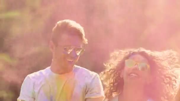 Två dansande par omfattas i färgat pulver, glada vänner njuter av part — Stockvideo