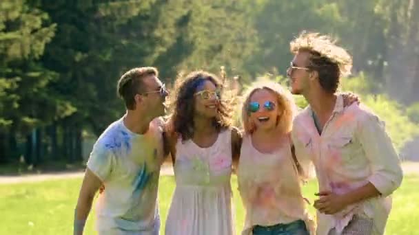 Jóvenes felices bailando en el festival Holi, lanzando polvo colorido al aire — Vídeo de stock