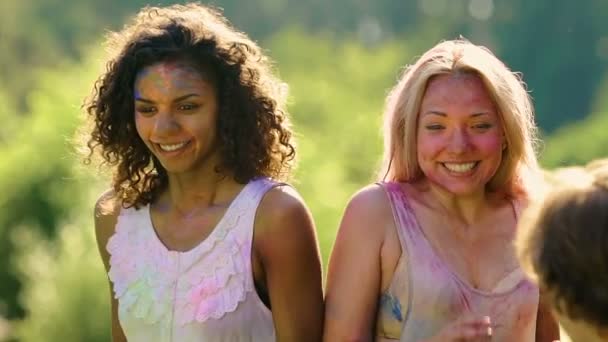 Junge Männer gießen Wasser auf hübsche Mädchen, Damen bei Holi-Fest mit Farbe bedeckt — Stockvideo