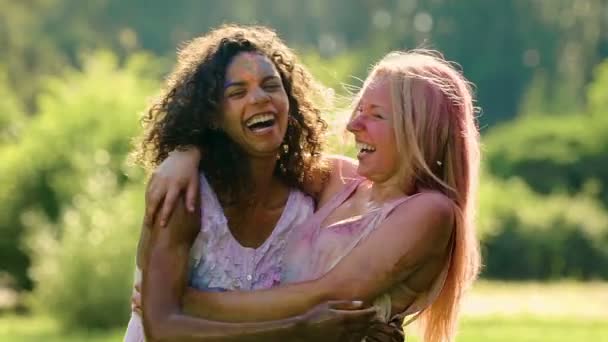 Amis éclaboussant l'eau sur les filles couvertes de peinture en poudre au festival Holi — Video